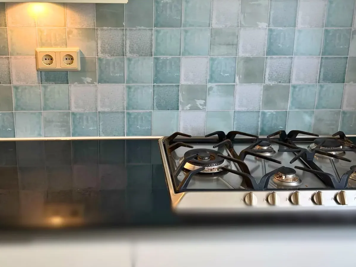 Antieke tegel achterwand Keuken met DW Solid spatwand op de achterwand in combinatie met een gasfornuis.