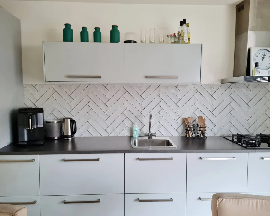 Weiße Fischgrät Herringbone Küchenrückwand DW1067 mit subtilen Fugenlinien in moderner Küche