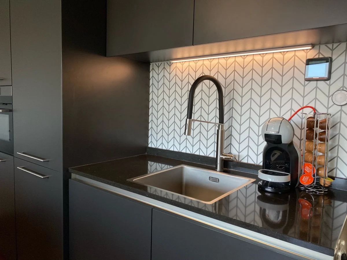 Hip Strepen spatwand DW3005 met grijs chevronpatroon in een donkere keuken