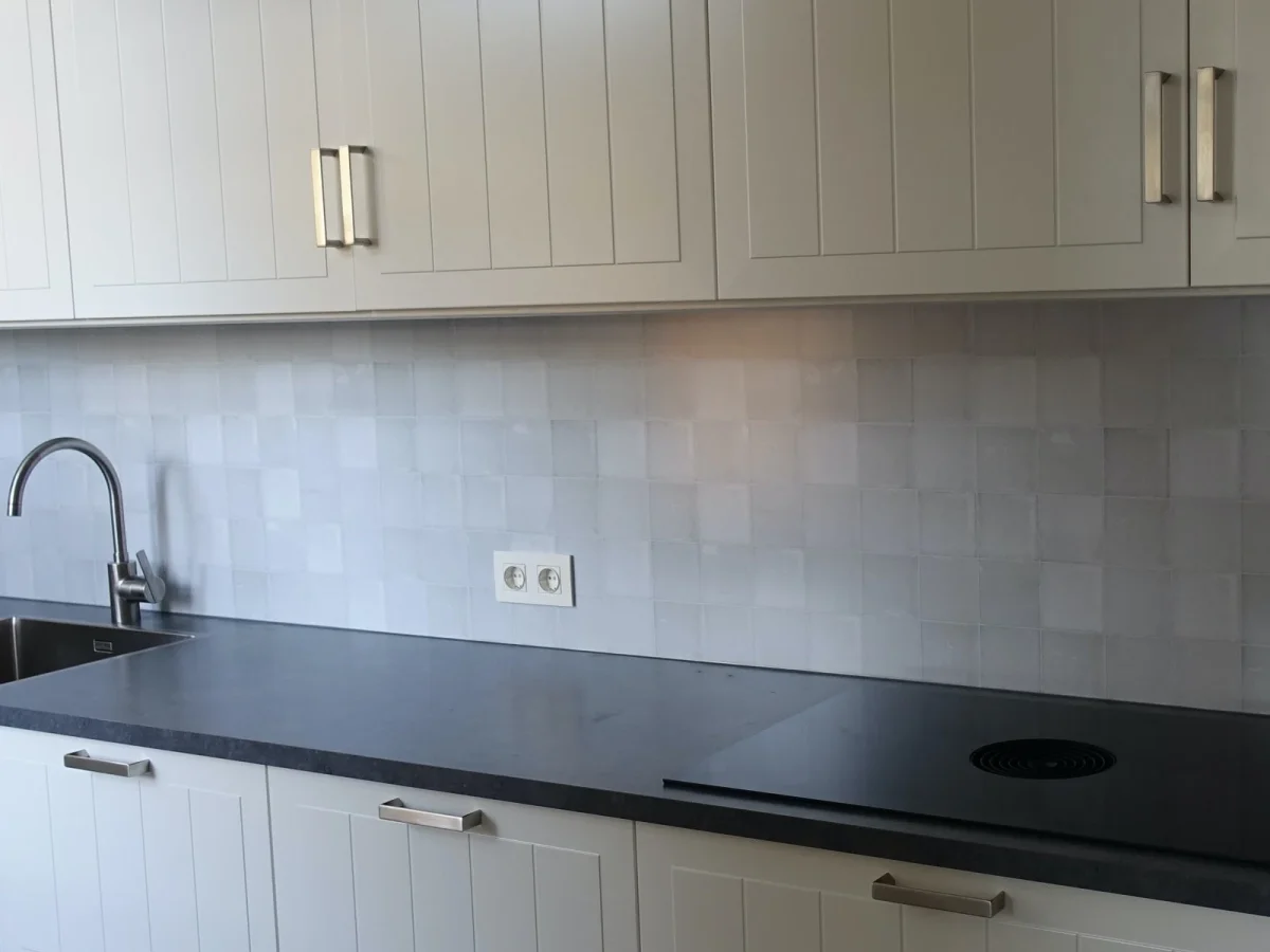 White Lilac antique tile backsplash in light lilac tones installed in kitchen with white cabinets and dark countertop