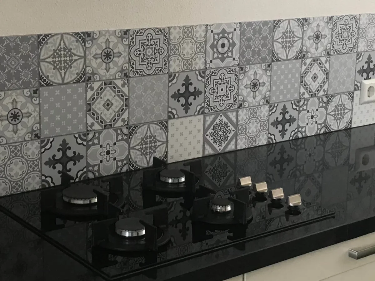 Portuguese tile backsplash Star Dust DW3302 with grey azulejo patchwork behind black gas hob