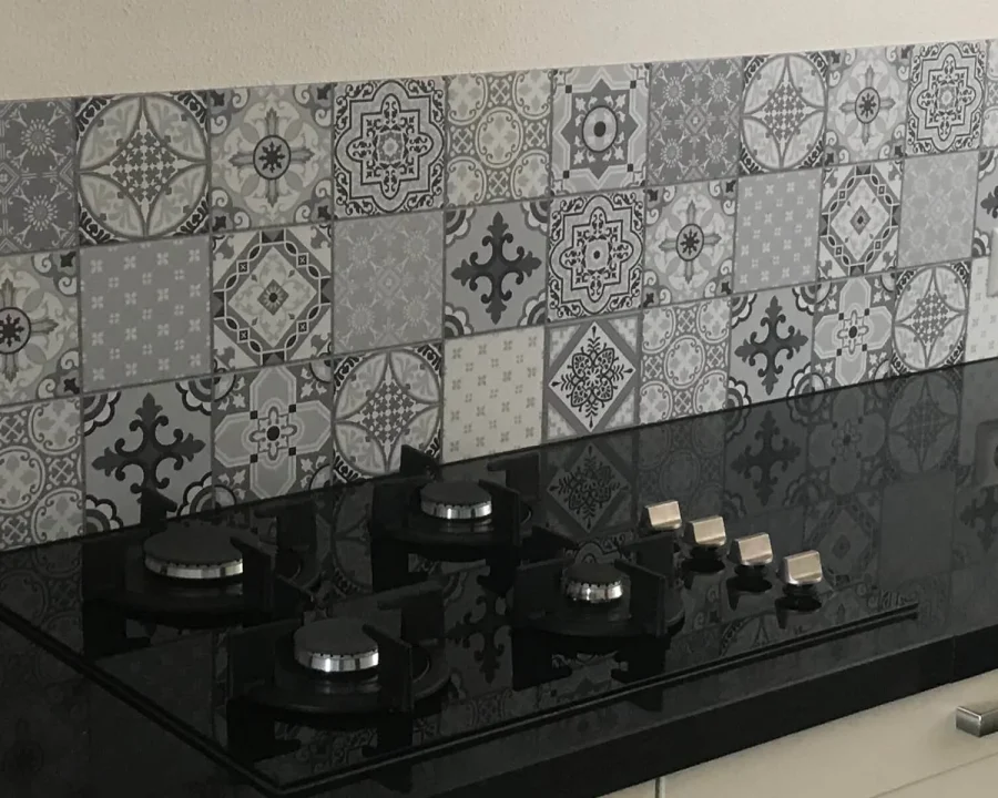 Portugese tegel spatwand Star Dust DW3302 met grijs azulejo-patchwork achter zwarte gaskookplaat