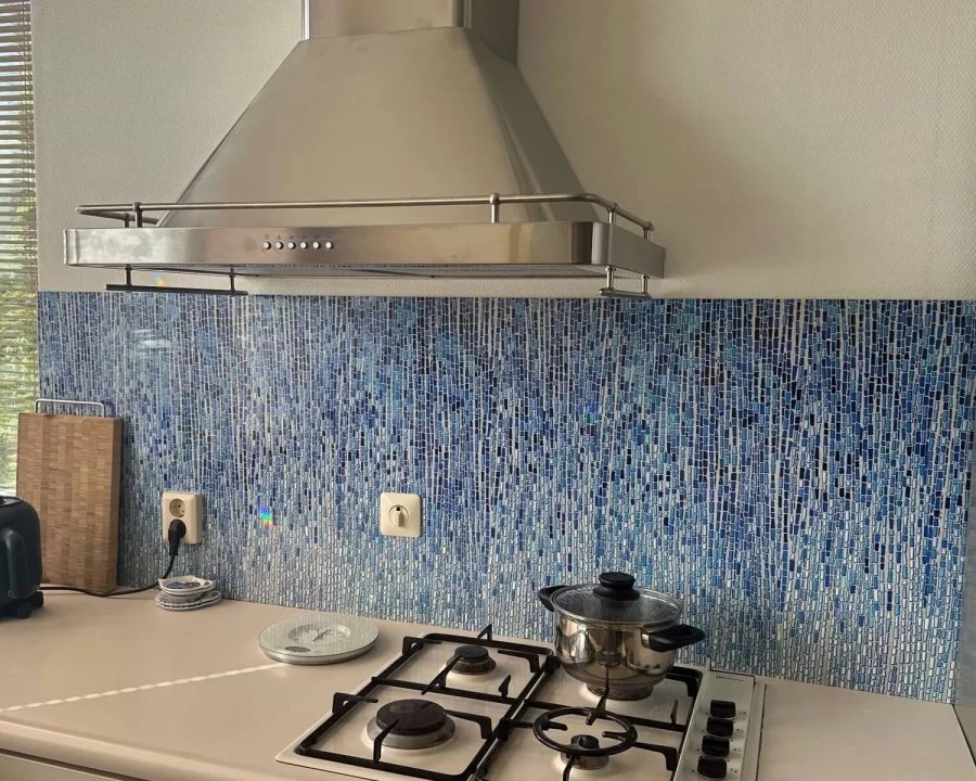 Blue Glaze Mosaik Küchenrückwand DW447901 mit vertikalen blauen Streifen montiert in Küche mit weißer Arbeitsplatte und Edelstahl-Dunstabzugshaube