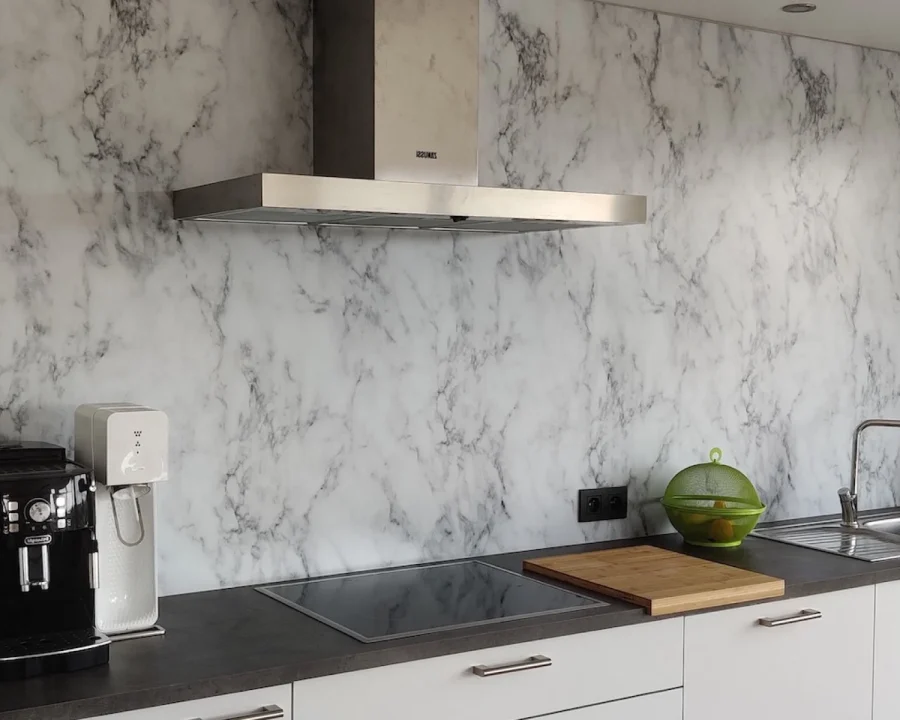 Witte marmerlook spatwand DW7337 met Carrara-stijl adering in keuken met donker werkblad en afzuigkap
