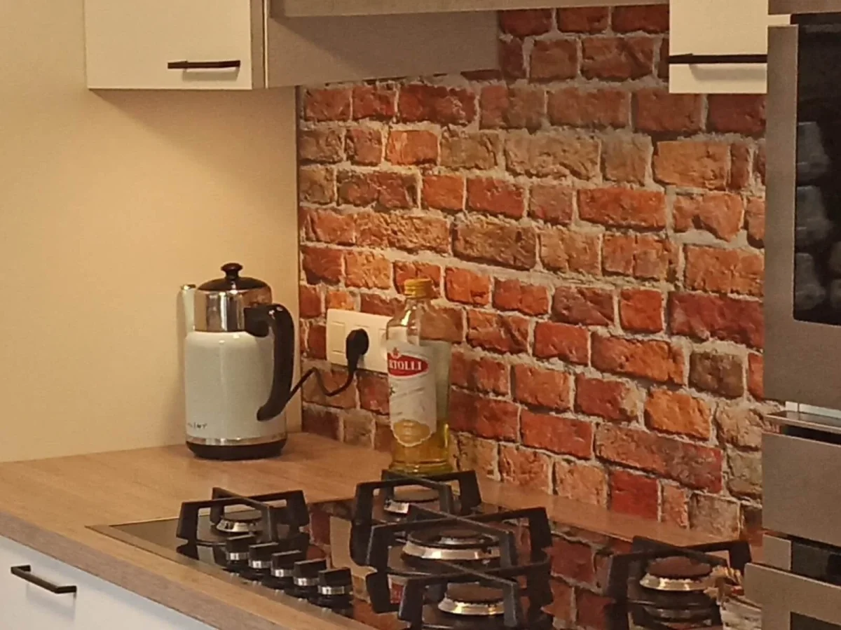 Rode bakstenen muur spatwand DW7384 in keuken met gasfornuis en houten werkblad
