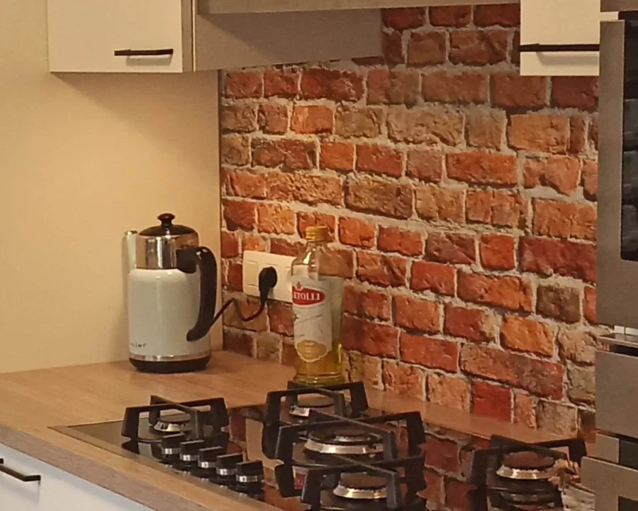 Rode bakstenen muur spatwand DW7384 in keuken met gasfornuis en houten werkblad