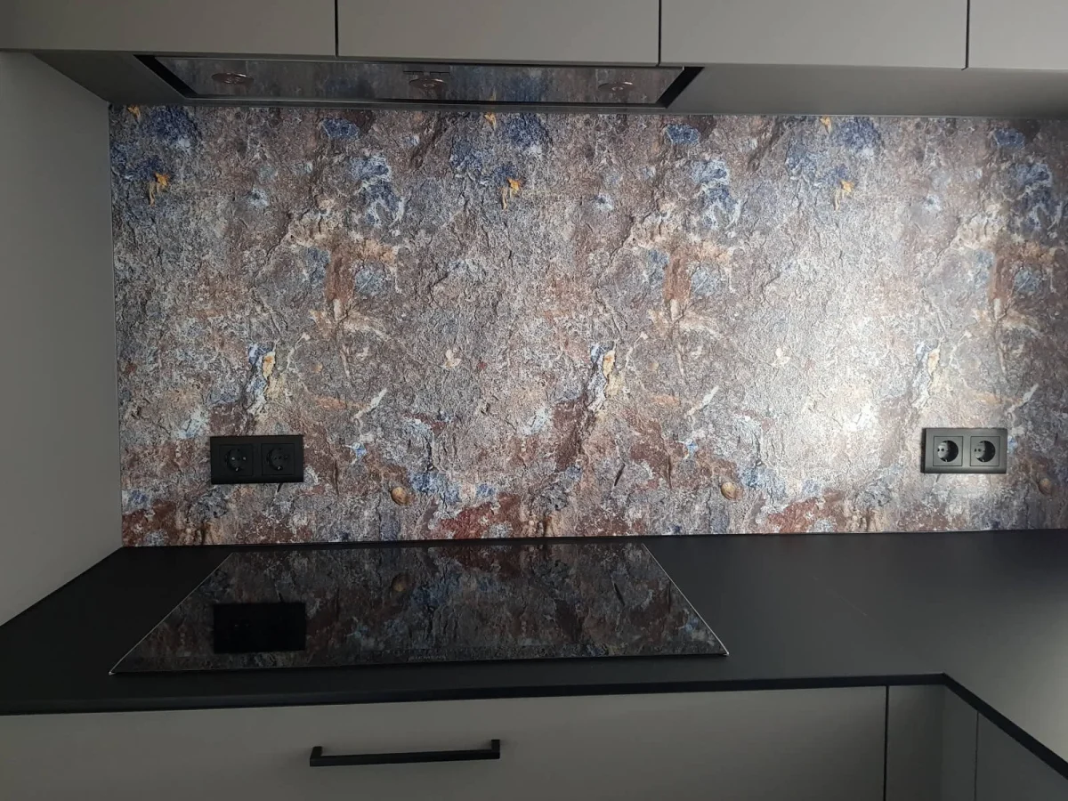 Keuken achterwand met een rots motief bij de klant gemonteerd. Gecombineerd met twee zwarte wandcontactdozen.