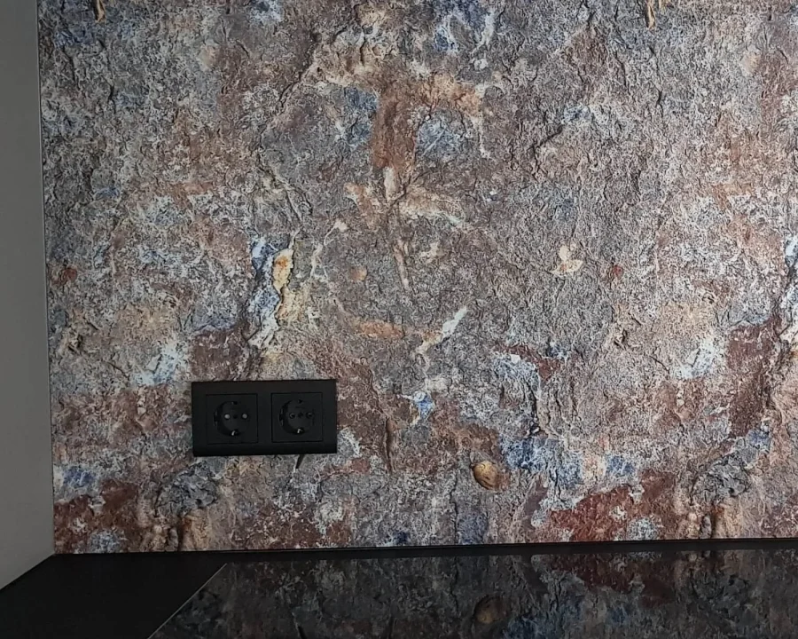 Stone and rock backsplash DW7405 with grey-brown rock texture mounted above dark worktop with black sockets