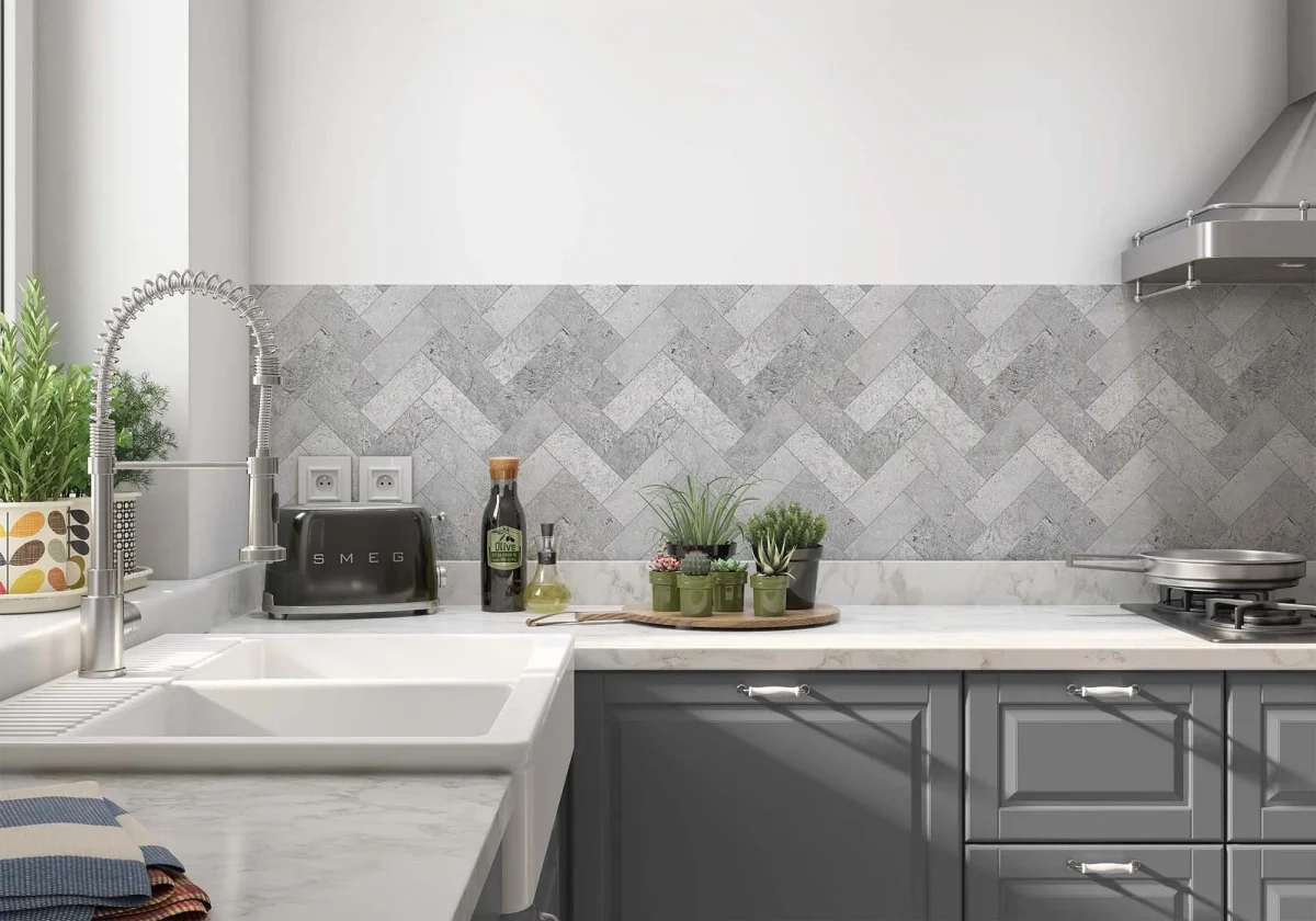 Grijze visgraat herringbone tegellook spatwand DW8530 in moderne keuken met donkergrijze kasten en marmeren werkblad