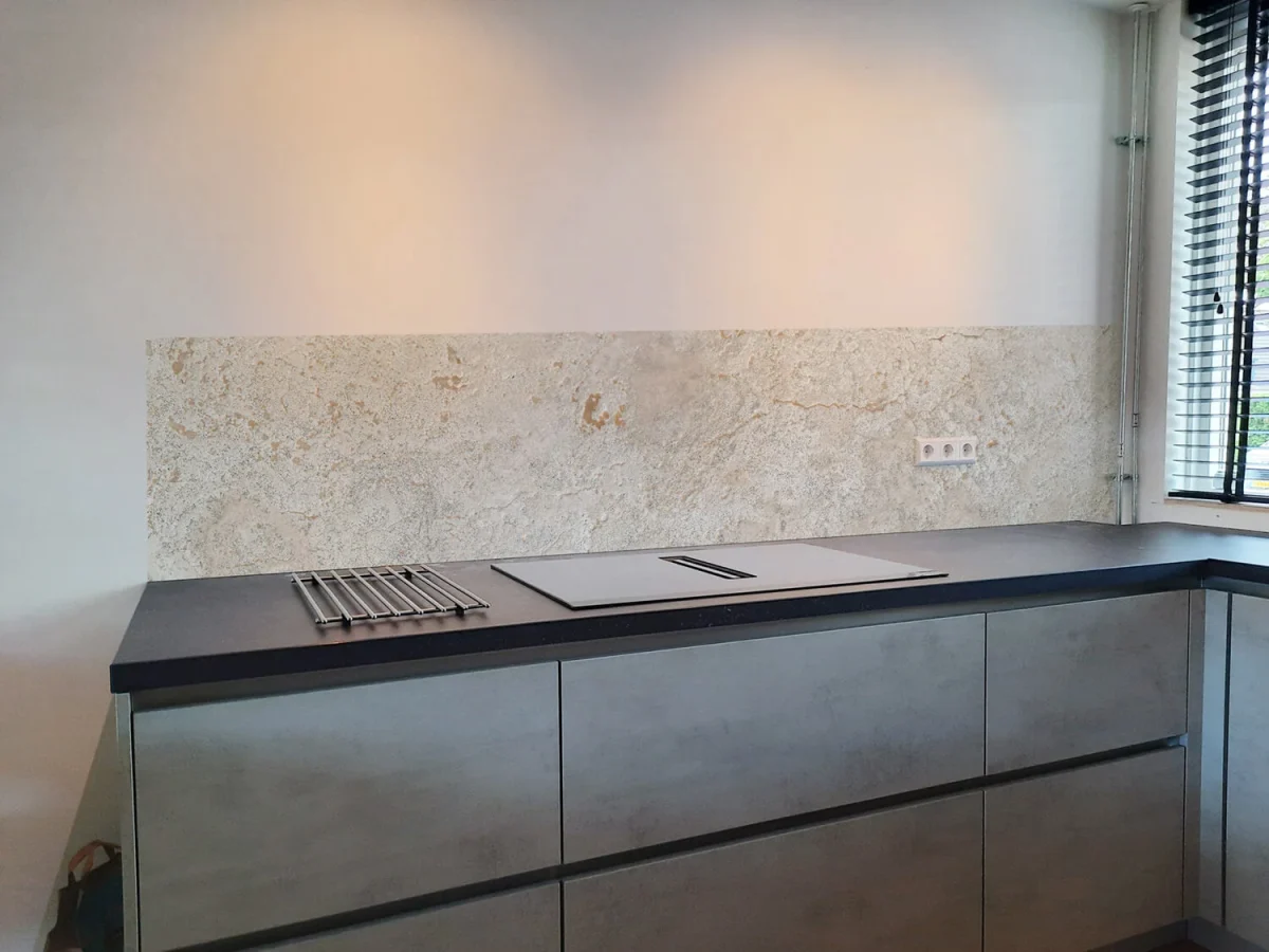 Helle Kalkstein-Küchenrückwand DW8624 in Creme- und Sandtönen hinter moderner Küche mit dunkler Arbeitsplatte