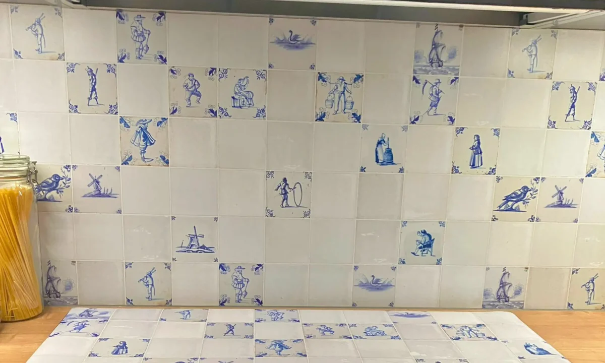 Detailfoto van Delfts blauwe keukenachterwand met grote en kleine tegels bij klant thuis