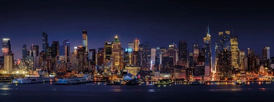 Panoramische nachtfoto van de skyline van New York Manhattan met verlichte wolkenkrabbers en reflectie in de Hudson River