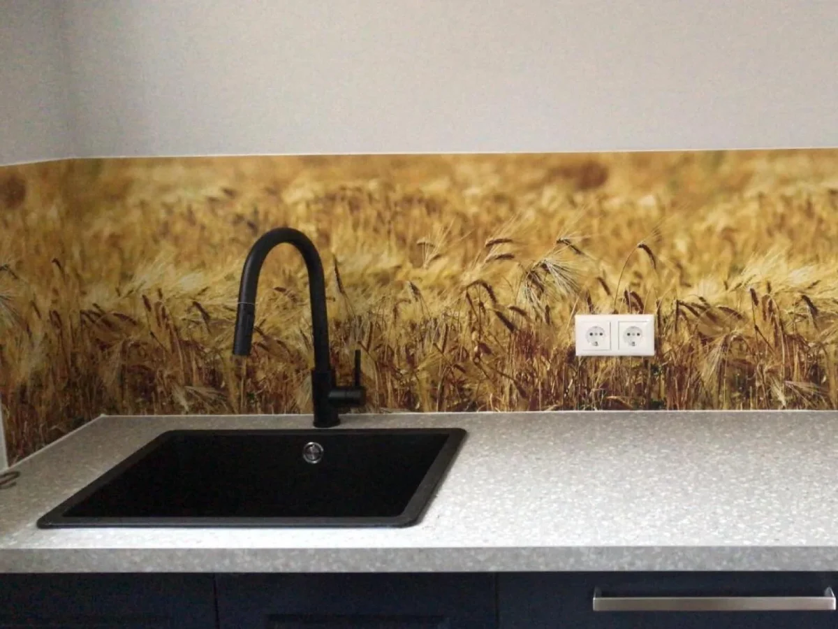 Keuken met spatwand van close-up goudgeel korenveld met rijpe tarwearen naast donkere spoelbak