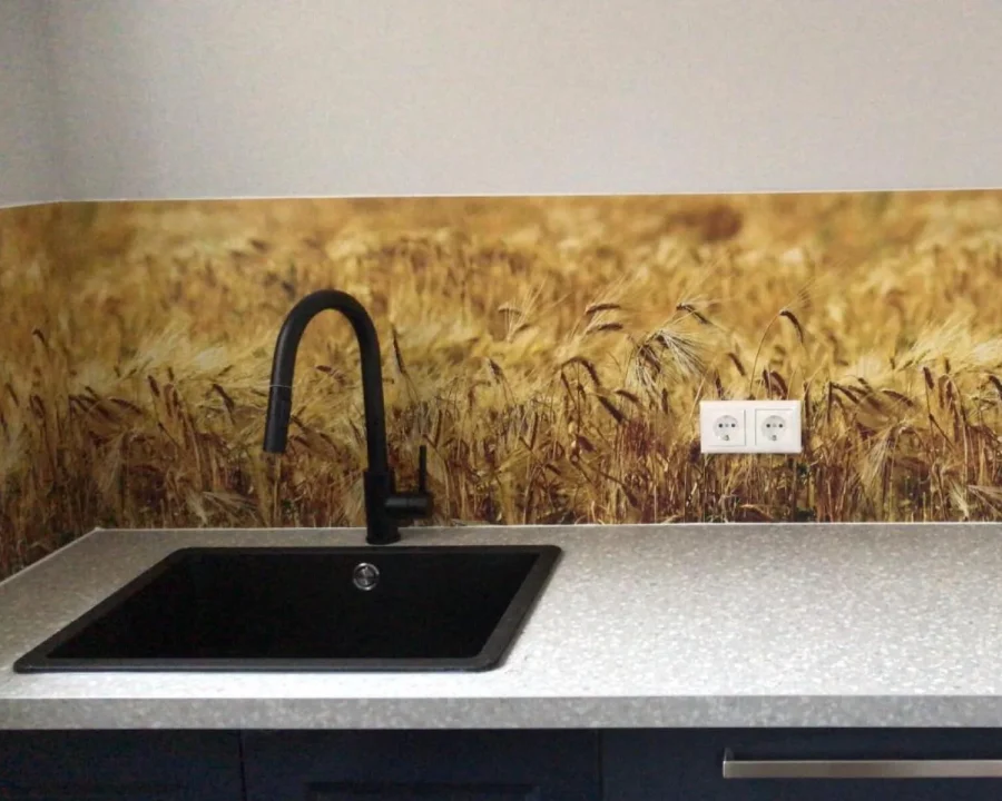 Keuken met spatwand van close-up goudgeel korenveld met rijpe tarwearen naast donkere spoelbak