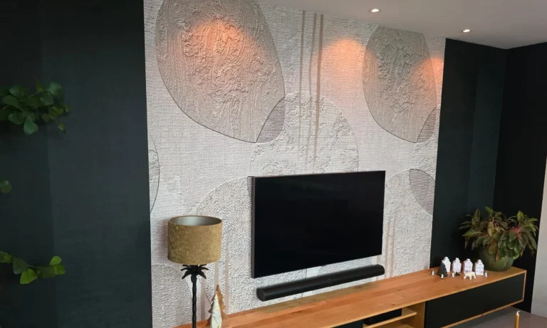 Behang met een licht reliëfdessin achter een tv-meubel in een donkere woonkamer