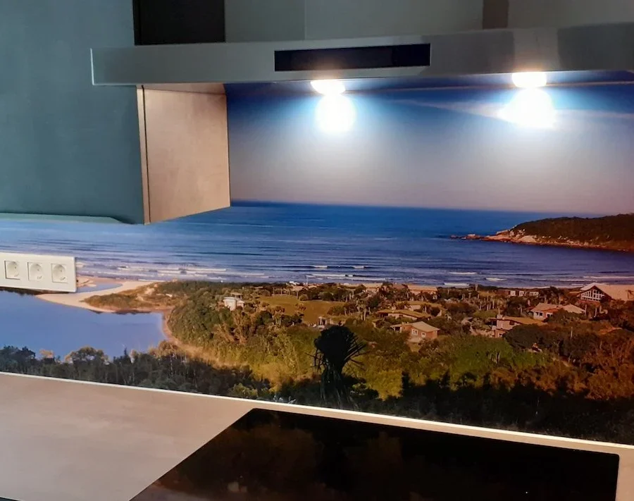 Küche mit panoramischer Küstenfoto-Küchenrückwand mit Bucht, Sandstrand und grünen Hügeln unter blauem Himmel